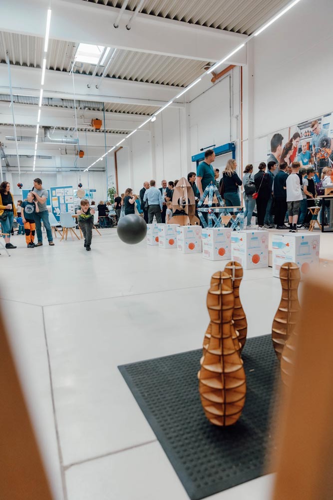 Kind spielt mit lasergecutteten Bowliong bei der Lange Nacht der Forschung im Innovation Lab